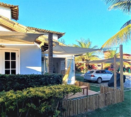 Un coche blanco aparcado delante de una casa en SUITE DA FRENTE COM COPA, WIFI E ACESSO INDEPENDENTE, en Búzios