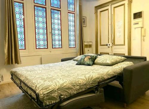 - un lit dans un dortoir doté de vitraux dans l'établissement Le Golden magnifique studio Toulouse centre, à Toulouse