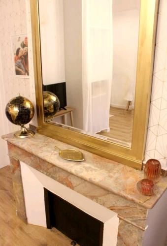 un miroir installé au-dessus d'un comptoir en marbre dans l'établissement Le Golden magnifique studio Toulouse centre, à Toulouse
