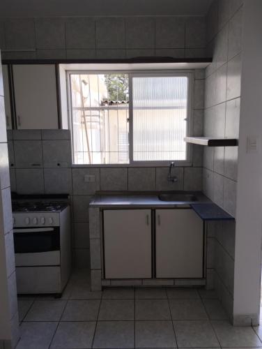 een kleine keuken met een wastafel en een raam bij Espaço do Bem Recife in Recife