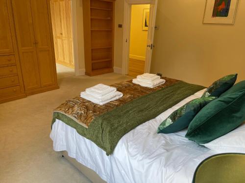 a large bed with towels on top of it at Stunning Thameside Apartment in Henley on Thames