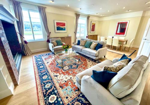 a living room with couches and a rug at Stunning Thameside Apartment in Henley on Thames