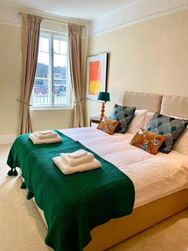 a bedroom with a bed with two towels on it at Stunning Thameside Apartment in Henley on Thames