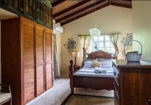 a bedroom with a wooden bed and a window at Lush Green Villa with mountain and garden view in Castries