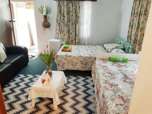 a small room with two beds and a table at Central Nadi - Lodge 2 in Nadi