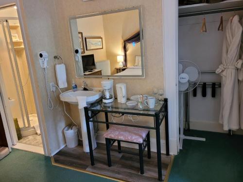 La salle de bains est pourvue d'un lavabo et d'un miroir. dans l'établissement Ruby Manor Bed & Breakfast, à Gananoque