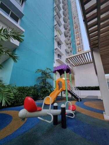 un parque infantil con un tobogán y una silla en un edificio en The Gemini Studio, en Bacolod