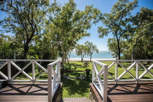a wooden bridge with a view of the beach at Cottonwood Beachfront, Port Douglas in Oak Beach