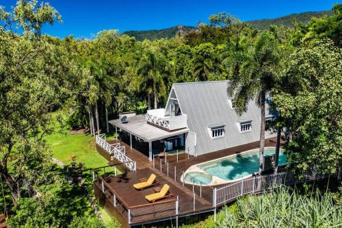 an aerial view of a house with a swimming pool at Cottonwood Beachfront, Port Douglas in Oak Beach