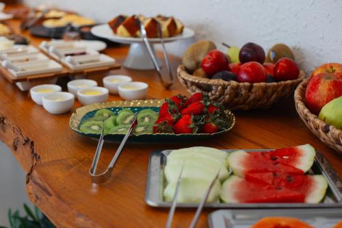a table topped with plates of fruit and desserts at Villa Toscana - Vale dos Vinhedos in Bento Gonçalves