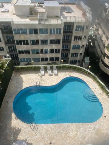 an empty swimming pool in front of a building at Habitación Frente a la Bahia con baño privado in Panama City