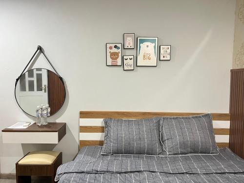 una camera da letto con un letto e uno specchio sul muro di Green Jungle Homestay - Phù Hợp Gia Đình Từ 10 - 15 Người Lớn & 5 Trẻ Em - Bãi Đậu Xe Ô Tô, Sân BBQ - Miễn Phí Sử Dụng Dịch Vụ Hồ Bơi Cách Homestay 3 Phút Đi Bộ - 7 Phút Đi Bộ Đến Biển - 5 Phút Đến Chợ Hải Sản Phú Thuỷ a Phan Thiet