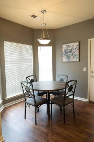 a dining room with a table and four chairs at Charming 2BD/1BA w/ Gym, Pool, BBQ Grill in Tupelo