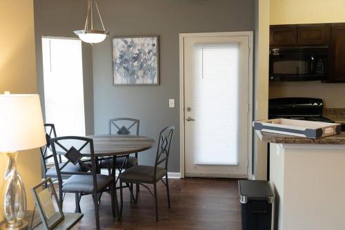 a kitchen and dining room with a table and chairs at Charming 2BD/1BA w/ Gym, Pool, BBQ Grill in Tupelo