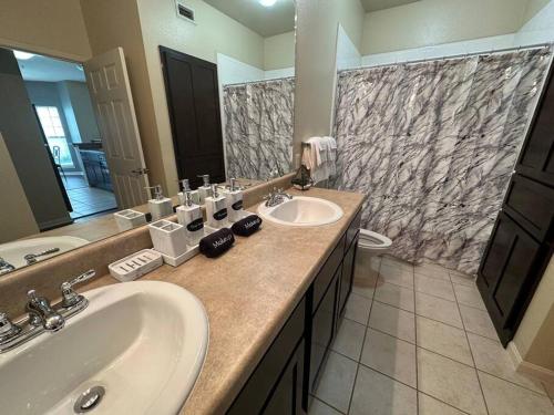 uma casa de banho com 2 lavatórios e um espelho grande em Charming 2BD/1BA w/ Gym, Pool, BBQ Grill em Tupelo