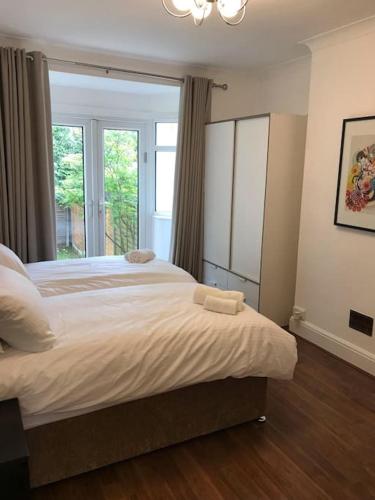 a bedroom with a large bed and a window at Spacious Kosher Flat in Golders Green in London