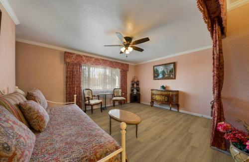 a living room with a couch and a ceiling fan at Carmel Inn & Suites in Carmel