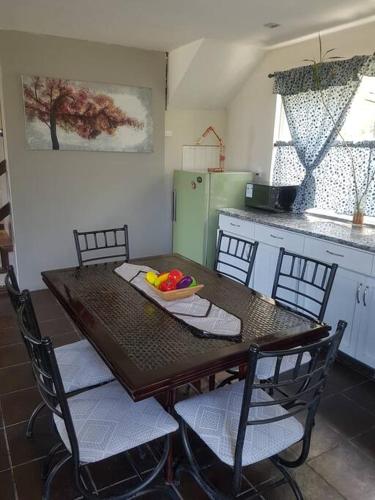 昆卡的住宿－El Descanso，厨房配有木桌、椅子和一碗水果