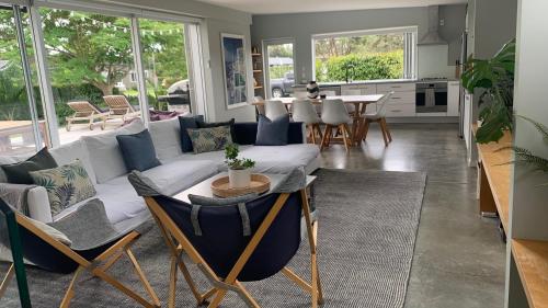 a living room with a couch and a table at Getaway Bach Whangapoua in Coromandel Town