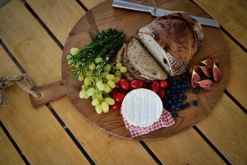 a plate of bread and fruit on a table at Getaway Bach Whangapoua in Coromandel Town