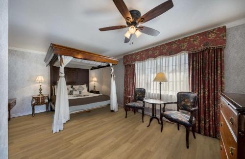 Carmel Inn & Suites في كرمل: غرفة نوم بسرير ومروحة سقف