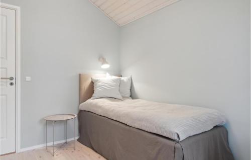una piccola camera da letto con un letto con una lampada sopra di 2 Bedroom Nice Home In Hornbk a Hornbæk