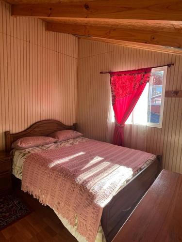um quarto com uma cama e uma janela vermelha em cabaña norma cerro castillo em Villa Cerro Castillo