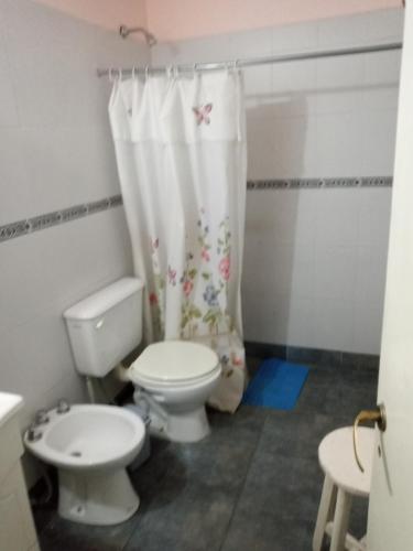 y baño con aseo y cortina de ducha. en Sai Ram en San Martín