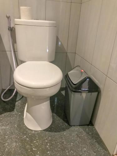 a bathroom with a toilet and a trash can at Heri house ubud in Ubud