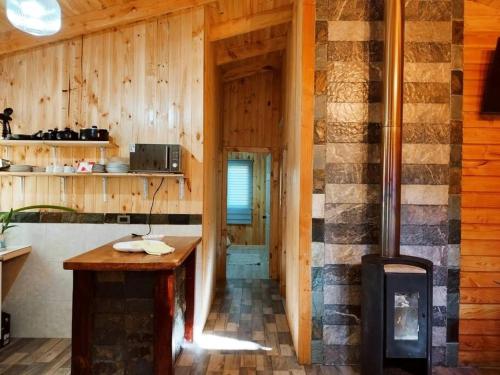 Casa de madera con cocina con fogones. en Arriendo Cabaña Entre Arrayanes., en Las Quemas del Salto