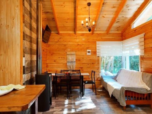 a living room with a couch and a dining table at Arriendo Cabaña Entre Arrayanes. in Las Quemas del Salto