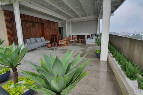a patio with a couch and some plants at Exclusive Apartment, Calzada Roosevelt in Guatemala
