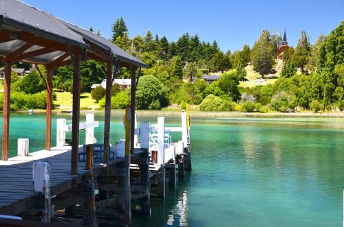 a dock with chairs and tables on a lake at La Francisca in San Carlos de Bariloche