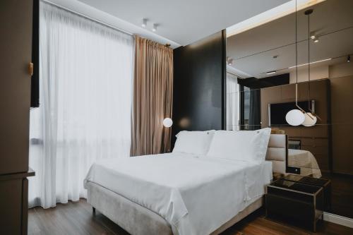 ein Schlafzimmer mit einem großen weißen Bett und einem Fenster in der Unterkunft POETICA BOUTIQUE SKY HOTEL in Neapel