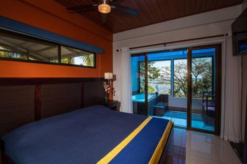 una camera con un letto e una grande porta a vetri di Ojochal Magnificent Ocean View a Ojochal