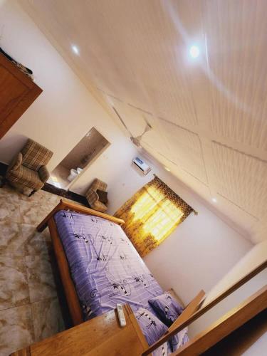 um quarto no sótão com uma cama e uma janela em Malikia apartment 2 em Brusubi