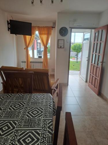 um quarto com uma cama, uma televisão e uma porta em Vientos del Sur em Río Gallegos