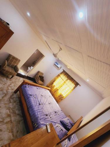 uma vista sobre um quarto com uma cama e uma janela em Malikia apartment 2 em Brusubi