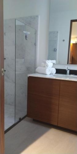 a bathroom with a shower and a sink with towels at Vgolf Casa Bonita Vista in Puerto Vallarta