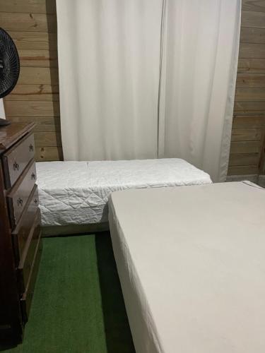 Duas camas individuais num quarto com uma cómoda e uma cama sidx sidx em KITNET cosntruçao quase já finalizada em Itapema