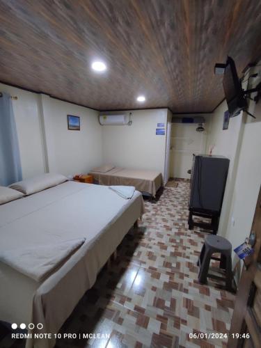a room with two beds and a flat screen tv at POSADA BLUE WAVE VIEW in Archibolds