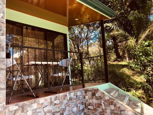 a screened in porch of a house with a chair at Casa Encantada offers you Two-Bedroom House, 1 Tiny Apartment & 3 Double Rooms in Manuel Antonio