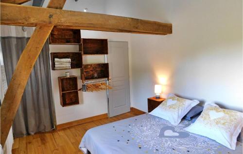 um quarto com uma cama e um feixe de madeira em Le Hangar em Castelnaud La Chapelle