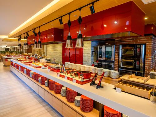a restaurant kitchen with red dishes on a counter at KAMENOI HOTEL Atami in Atami