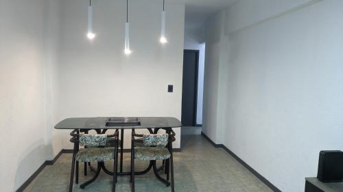 una mesa negra con sillas en una habitación vacía en Departamento Ñandú - 2 ambientes zona Güemes en Mar del Plata