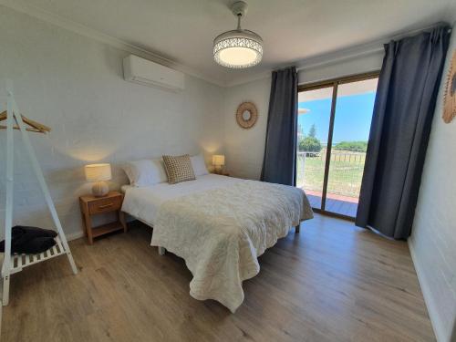 1 dormitorio con cama y ventana grande en The African Reef en Geraldton