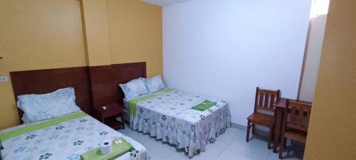1 dormitorio con 2 camas y 1 silla en Hotel ESPLENDOR, en Chiclayo
