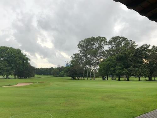 a view of a golf course with trees and a green at ApartOfCalcutta! in Kolkata