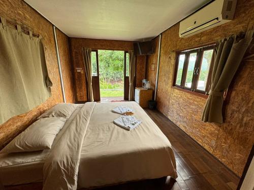 ein Schlafzimmer mit einem Bett in einem Zimmer mit Fenstern in der Unterkunft Mari Pai Resort in Pai