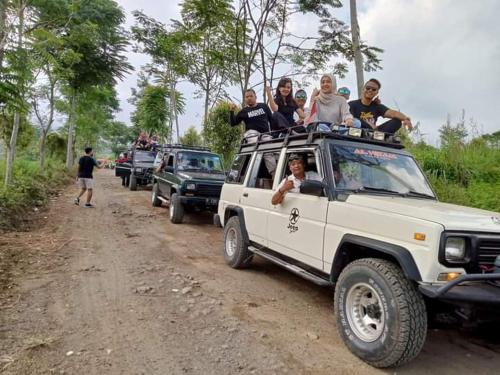 a group of people riding on the roof of a white truck at Dannu's Homestay Ijen and Bromo Tour in Banyuwangi
